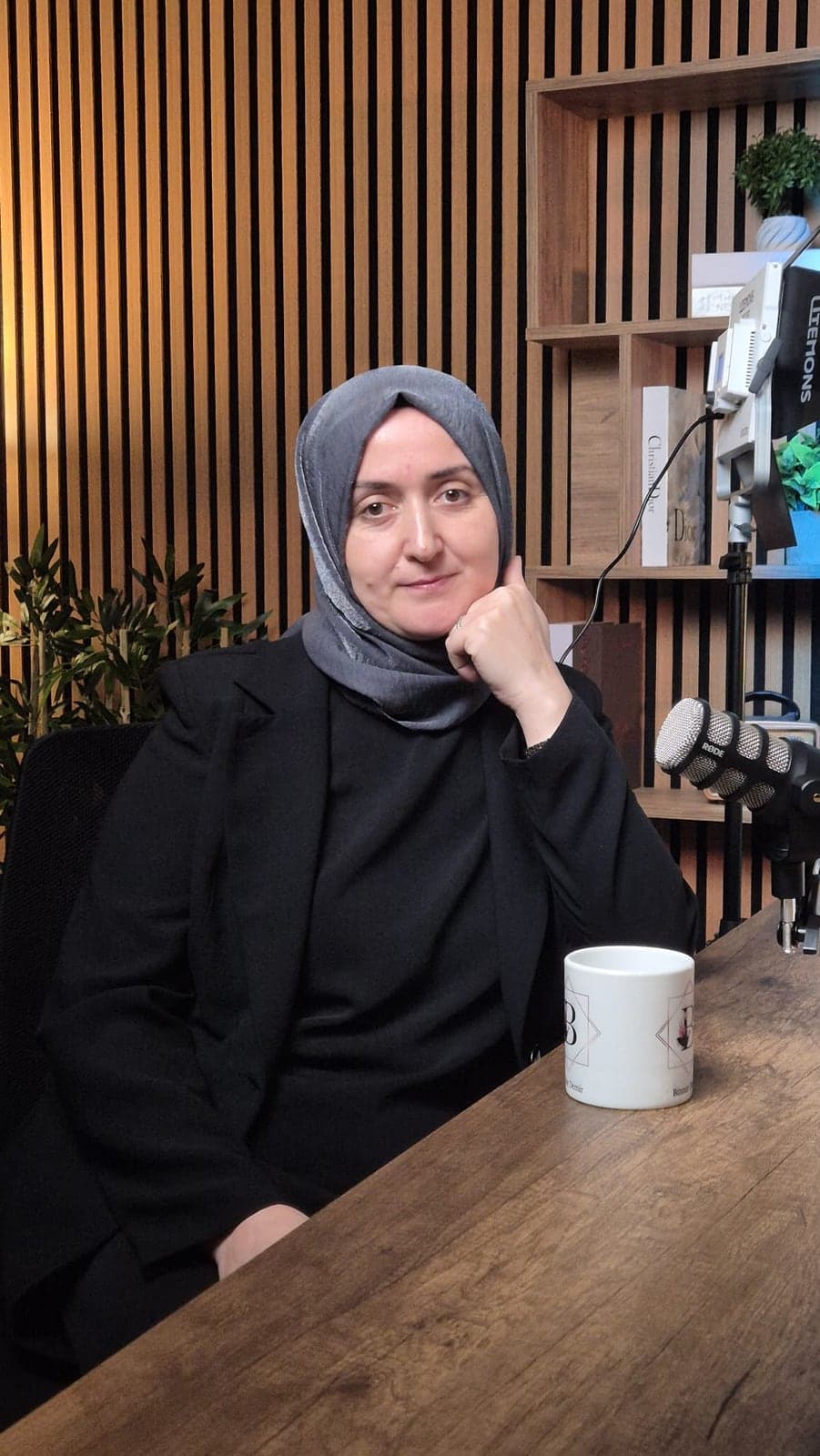 Binnur Demir masasında, elini yanağına dayamış